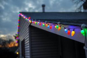 Outdoor multi-colored Christmas lights hanging on the eves on a house. 