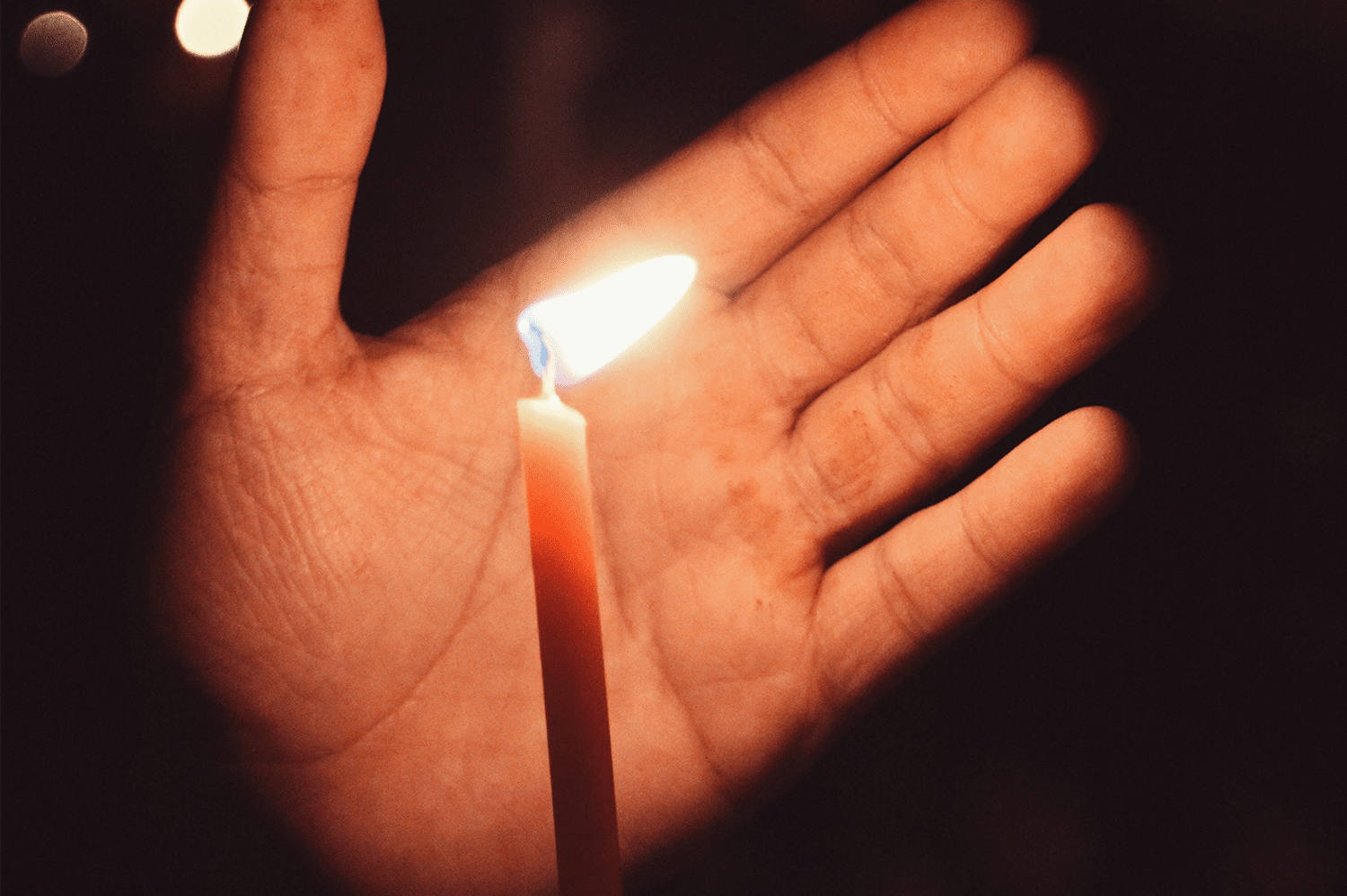 A man using a candle during a black out, something he kept for his power outage preparedness.