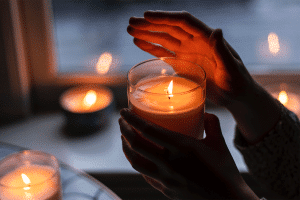 Person holding a light candle in the dark.