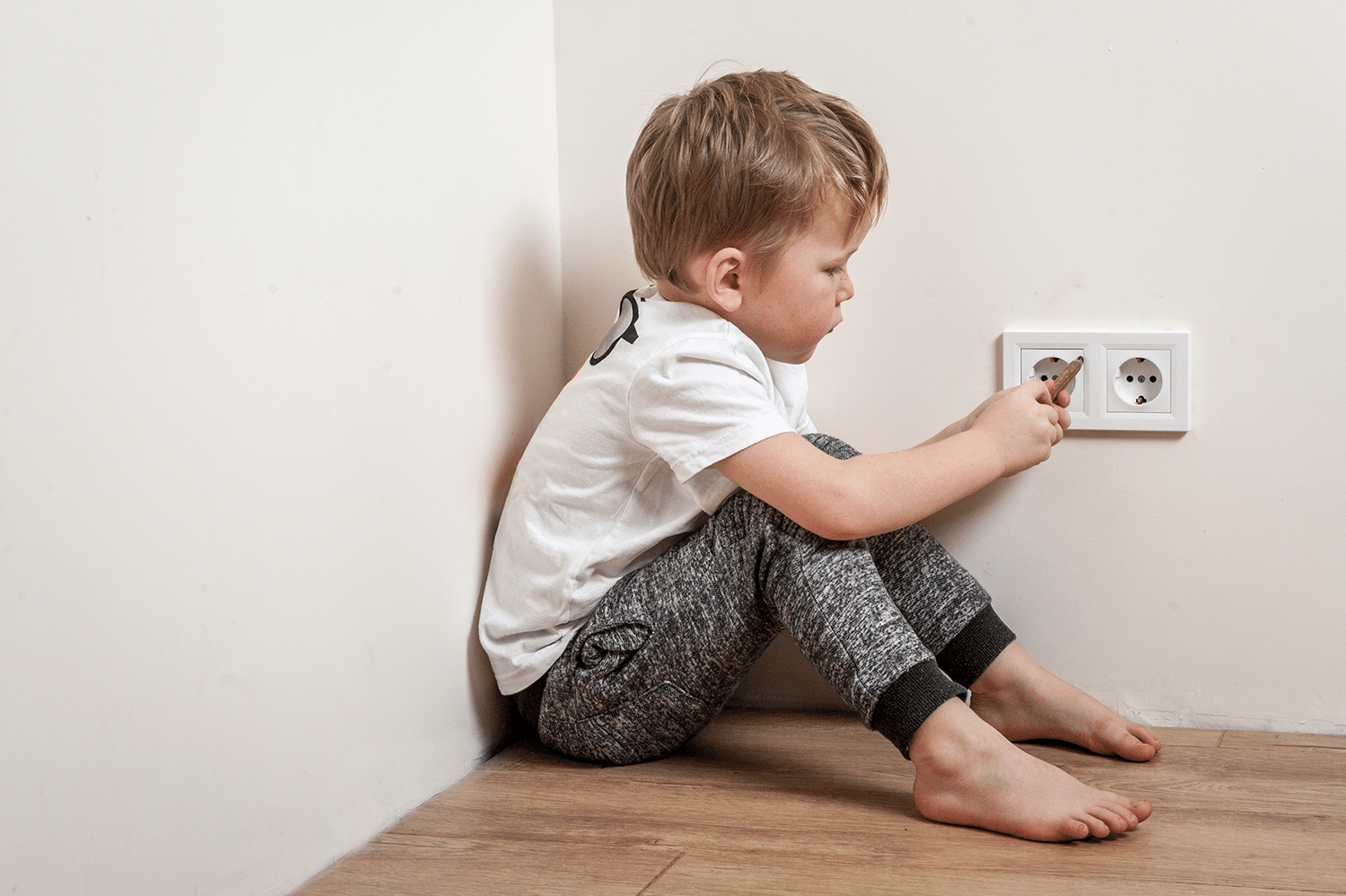 Kid sticking his finger in an outlet, a bad example of electrical safety.