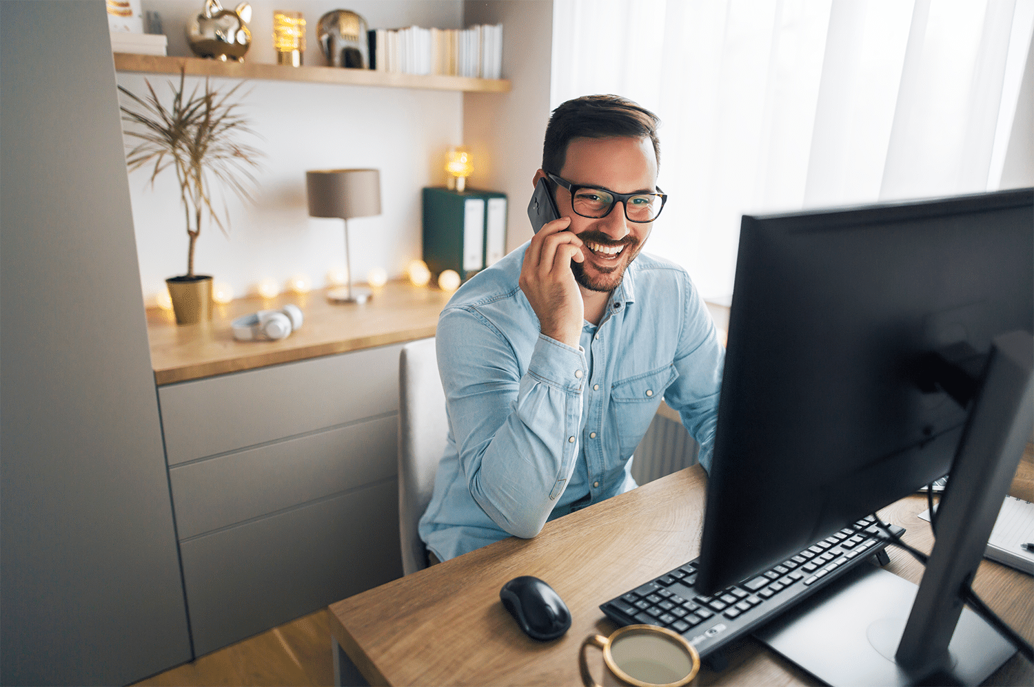 Man sitting in his home office on a phone call with electrical installations set up around him.