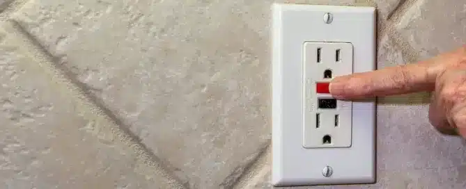 finger resetting a gfci outlet