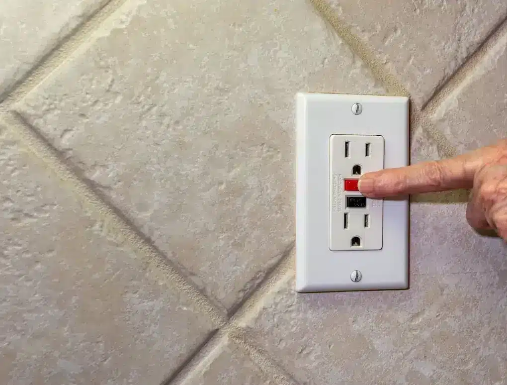 finger resetting a gfci outlet